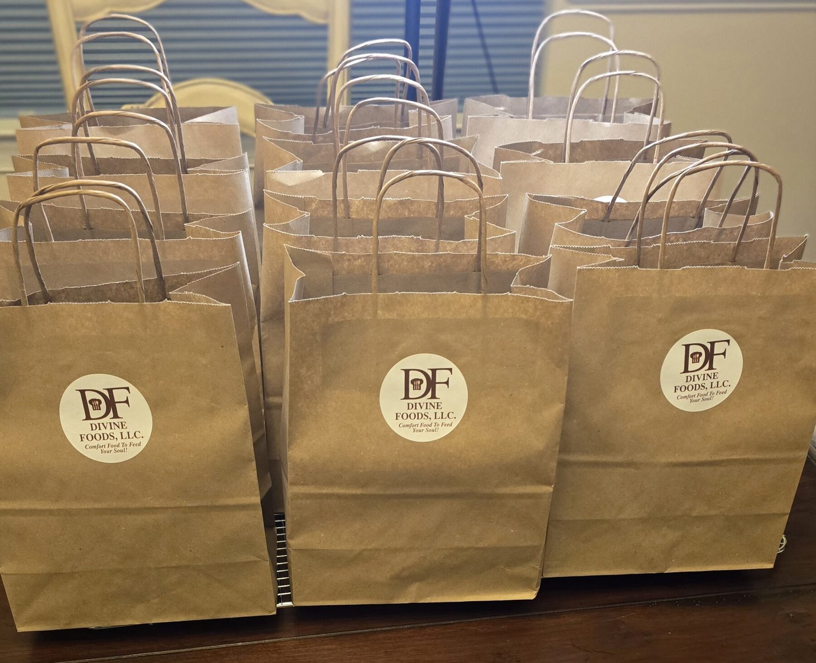 Rows of kraft bakery bags, each stamped with the round Divine Foods seal